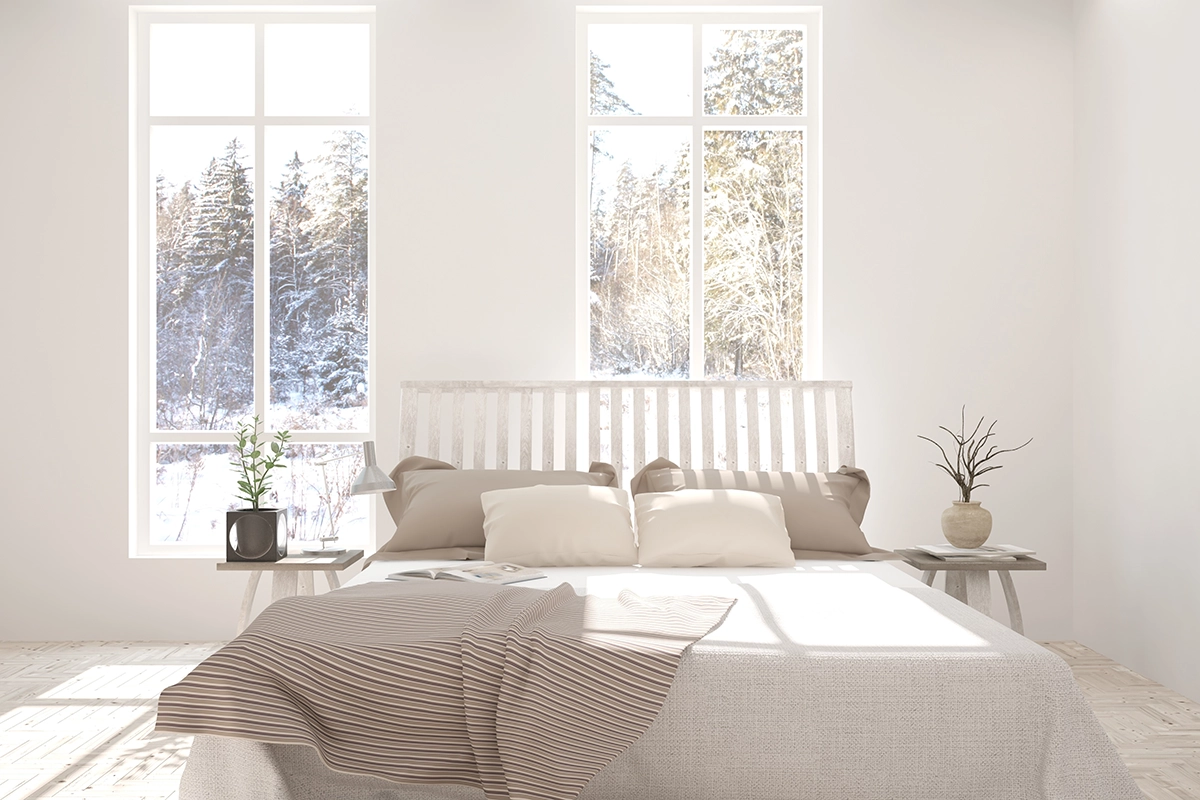 A white rustic bedroom with sun light shining through the window.