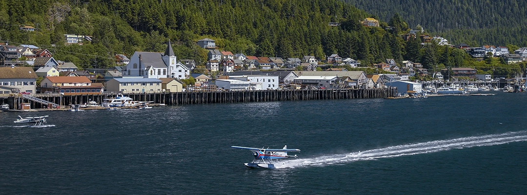 Float plane lands in the waters of the Tongass Narrows in Ketchikan, Alaska.