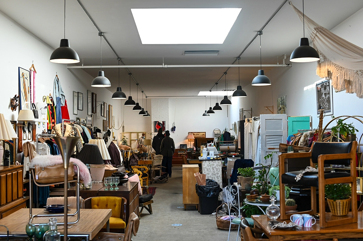 Interior of a thrift store filled with vintage furniture, clothes, and decor, highlighting secondhand shopping and used furniture sources.