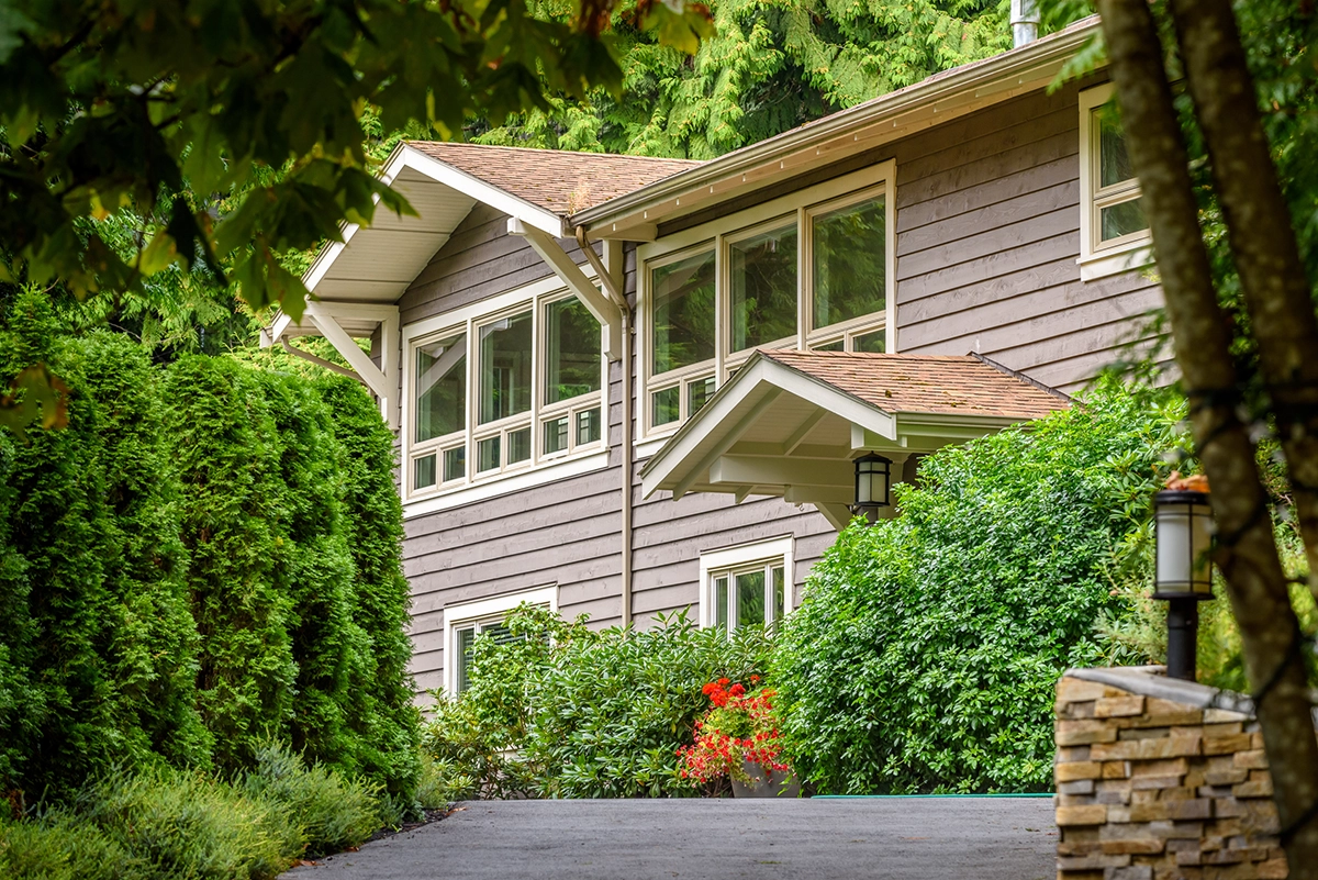 Beautiful residential home surrounded by lush greenery, symbolizing pest-free living and exterior rodent prevention.
