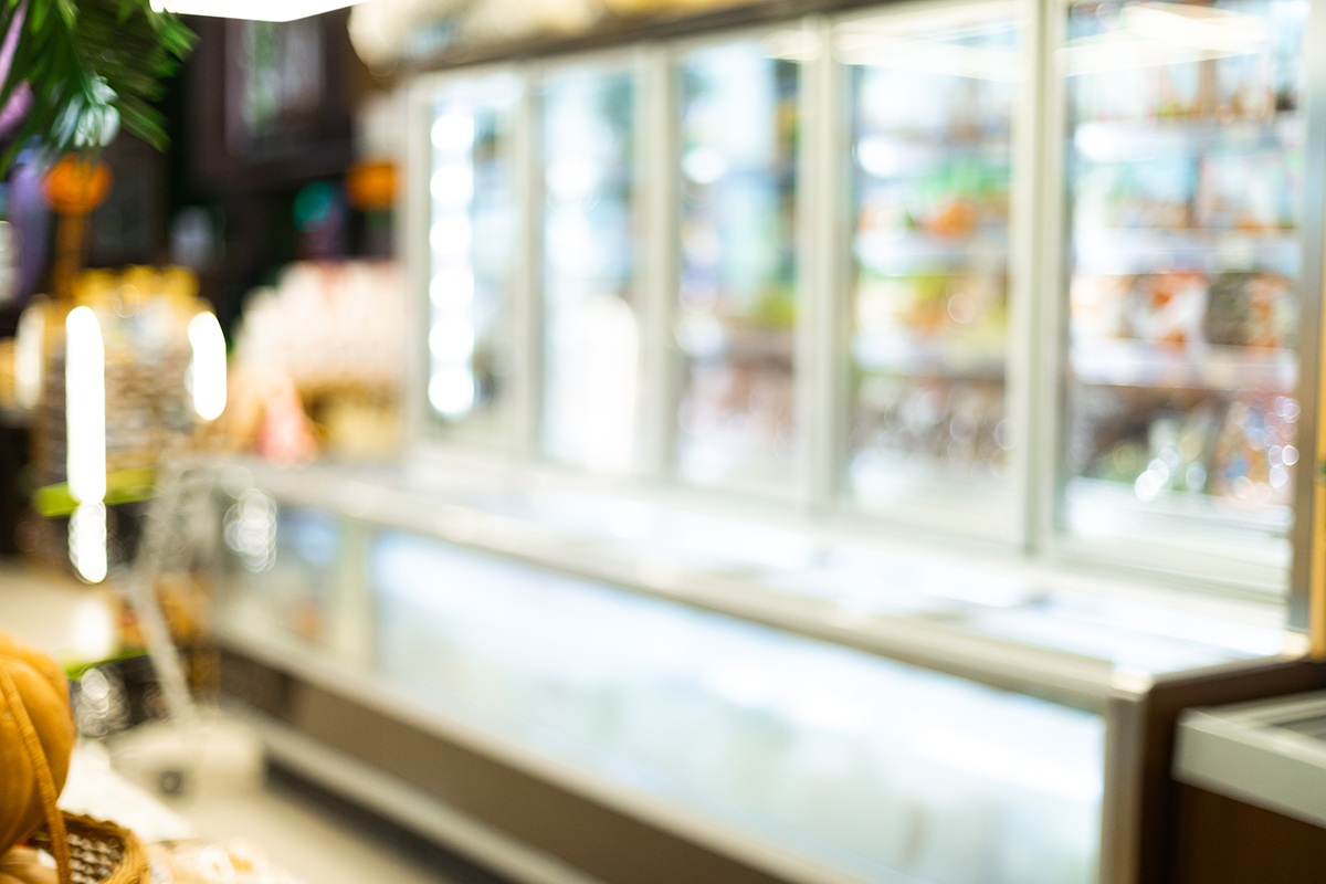 Out of focus deli counter with refrigerated display cases inside a closed food establishment