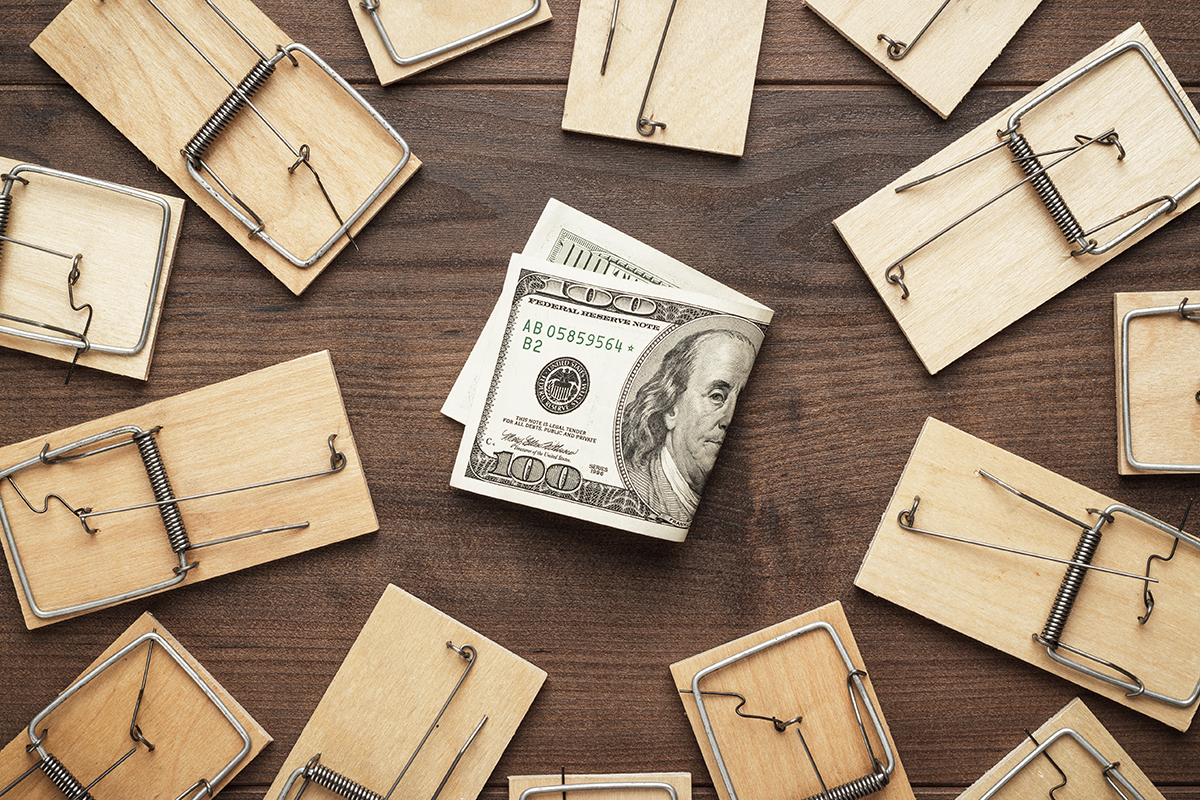 Mousetraps arranged around cash money symbolizing pest control costs and financial loss